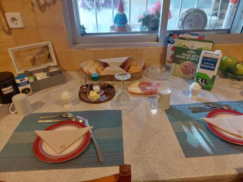 a table with plates and utensils and food on it at Llano del Beal in El Descargador