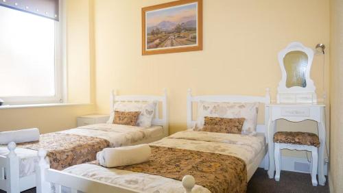 a bedroom with two beds and a picture on the wall at Cozy Central Apartment in Inverness