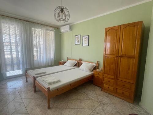 a bedroom with a bed and a wooden cabinet at KudevApartment1 in Nesebar