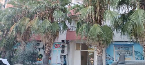 a building with palm trees in front of it at Terminal apartment- near North and South Terminal in Bregu i Lumit