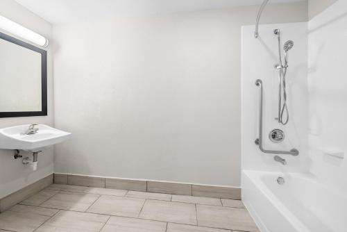 a white bathroom with a sink and a shower at Quality Inn Orlando Near International Drive in Orlando