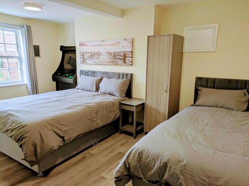 a bedroom with two beds and a cabinet and a desk at Castle View, 94-96 Friar Lane in Nottingham
