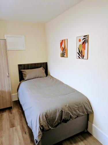 a bed in a bedroom with two pictures on the wall at Castle View, 94-96 Friar Lane in Nottingham