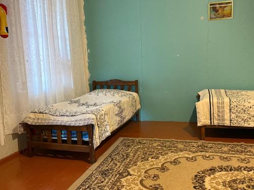 Una habitación con dos camas individuales y una alfombra. en Jancho's Home, 