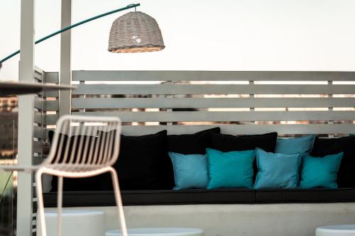 a black couch with blue pillows and a chair at Hotel Juliani - Boutique Hotel in St Julian's
