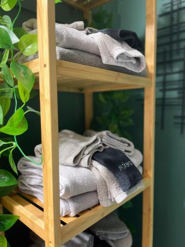 a wooden shelf with folded towels on it at *NEW* The Cozy Haven, 5 minutes to ATL airport in Atlanta