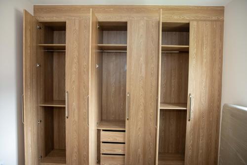 drewniana szafa z drewnianymi drzwiami i pustymi półkami w obiekcie Maison Paraíso, apartamento de lujo 1Hab w mieście Ciudad de Malabo
