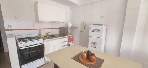 a kitchen with a counter with a stove and refrigerator at Monoambiente Montevideo in Rosario