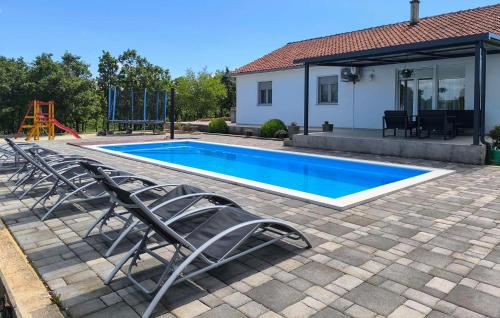 a swimming pool with chairs and a playground at Three-Bedroom Holiday Home In Vinjani Gornji in Aračići