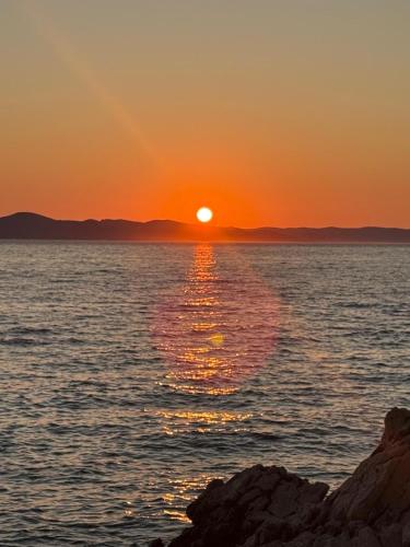 a sunset over the water with the sun setting at Mobile House Mona in Drage
