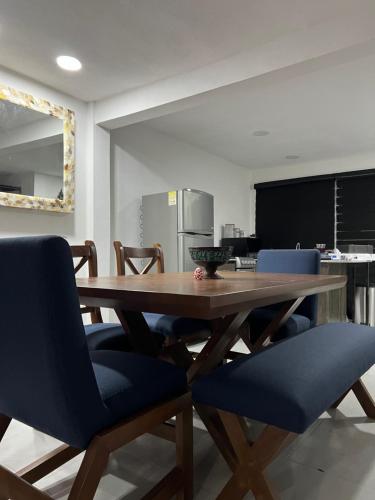 a dining room with a wooden table and blue chairs at Bonita casa nueva con alberca climatizada y aire acondicionado en Oaxtepec Morelos in Oaxtepec