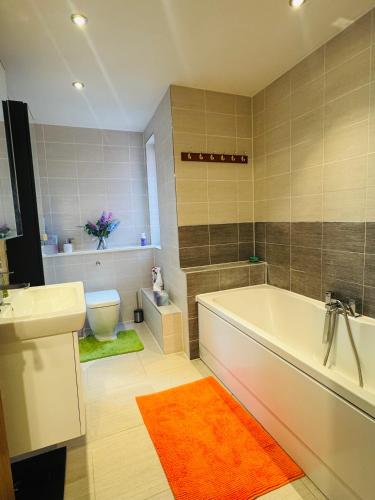 a bathroom with a tub and a sink and a toilet at Taylors Place 3bedroom 2Bath Modern House in Winchester Wifi 2FreeParking in Winchester