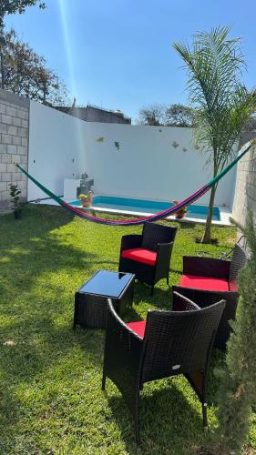 a group of chairs and tables next to a pool at Bonita casa nueva con alberca climatizada y aire acondicionado en Oaxtepec Morelos in Oaxtepec