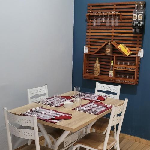 a dining room table with chairs and a table with wine glasses at Apartamento de 1 quarto para 4 hospedes in Oiapoque