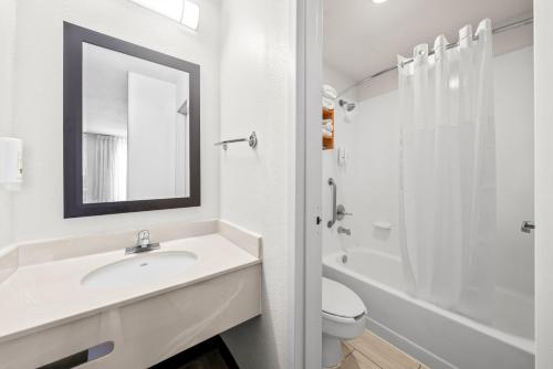 a bathroom with a sink and a toilet and a mirror at Quality Inn Orlando Near International Drive in Orlando