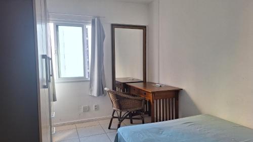 a bedroom with a desk and a mirror and a bed at Apartamento JTR Maceio AL in Maceió
