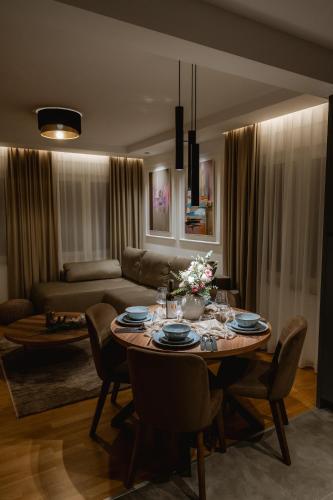 a living room with a table with chairs and a couch at Apartman Boutique Arandjelovac in Arandjelovac