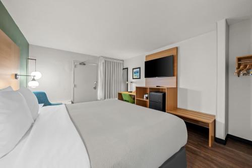a hotel room with a large bed and a desk at Quality Inn Orlando Near International Drive in Orlando