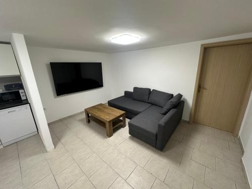 a living room with a couch and a flat screen tv at Apartment Dantéa - NEW 2025 in Izola