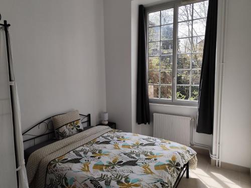 a bedroom with a bed and a large window at O'Couvent - Appartement 511 - 4 chambres - 87m2 - Premier étage in Salins-les-Bains