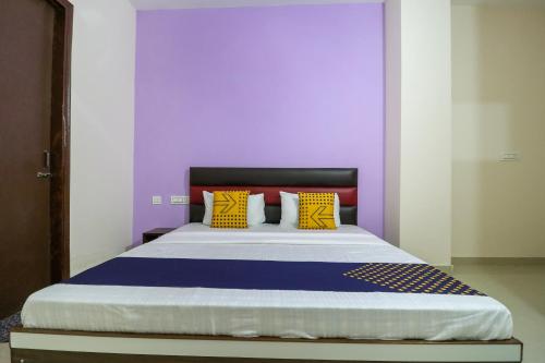 a bedroom with a large bed with a purple wall at Hotel O kalra in Zirakpur