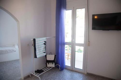 a room with a sliding glass door with blue curtains at stamatia's rooms in Agios Kirykos