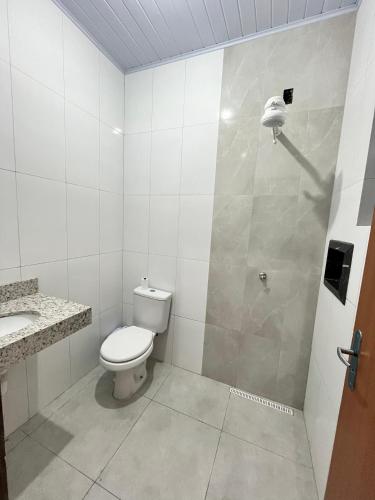 a white bathroom with a toilet and a shower at Benni Hotel Marabá in Marabá