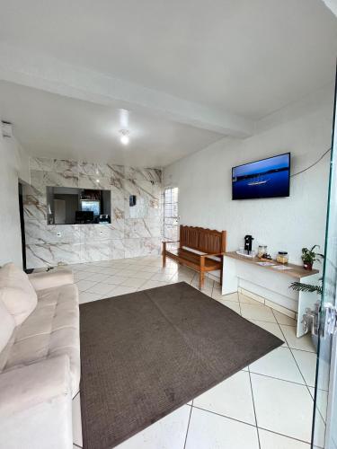 a living room with a couch and a stone wall at Benni Hotel Marabá in Marabá