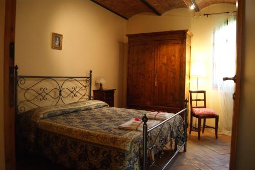 サン・ジミニャーノにあるPodere San Galganoのベッドルーム1室(ベッド1台、椅子、窓付)