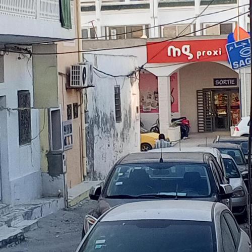 a street with cars parked in front of a store at Dar Al Yoser Guest house in Mahdia