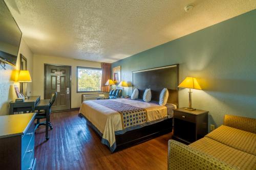 a hotel room with a bed and a desk at Regency Inn and Suites Bay City, Texas in Bay City