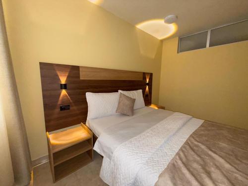 a bedroom with a large bed with a wooden headboard at Hotel Suyusama in Ipiales