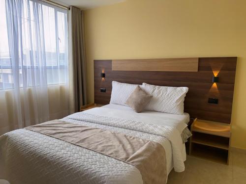 a bedroom with a large bed with a large window at Hotel Suyusama in Ipiales