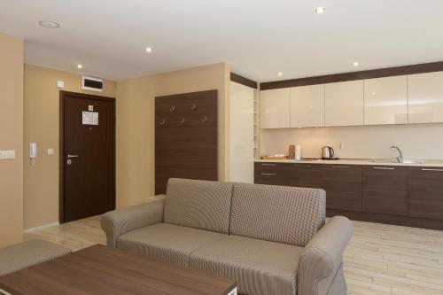 a living room with a couch and a kitchen at Aparthotel Paradiso in Nesebar