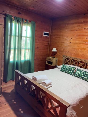 a bedroom with a bed with a wooden wall at Complejo de cabañas El Mangrullo in Larroque