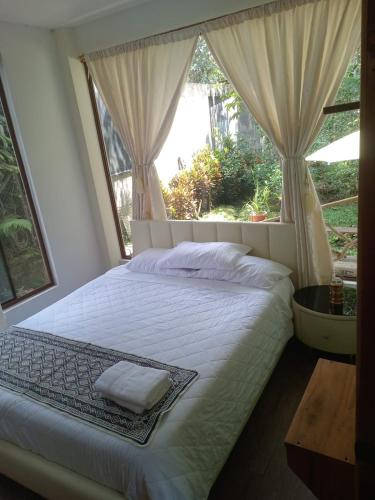 a bedroom with a large bed with a window at El Guayabal de Mindo in Mindo