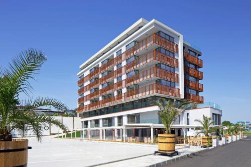 a tall building with palm trees in front of it at Aparthotel Paradiso in Nesebar