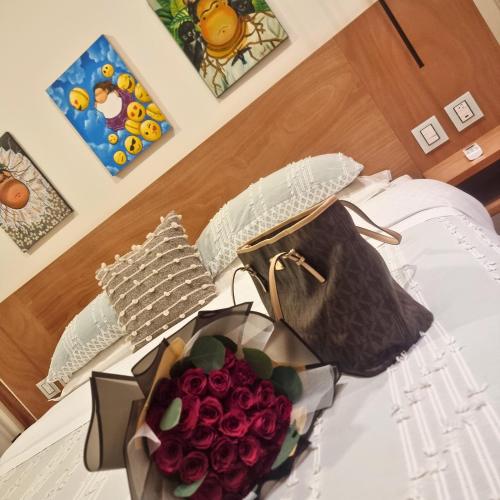 a bouquet of red roses and a purse on a bed at CASA DON JULIAN in Oaxaca City