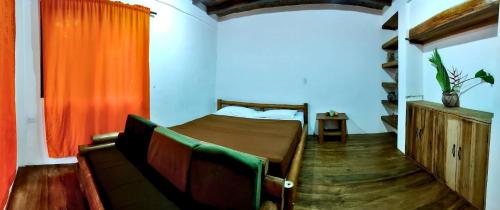 a bedroom with a bed and a couch at Green Lodge - Ayampe in Ayampe