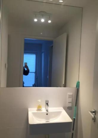 Un baño con lavabo y un espejo grande. en rooms WC separate, TV, en Bečići
