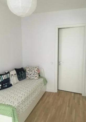 Una habitación blanca con una cama con almohadas y una puerta. en rooms WC separate, TV, en Bečići