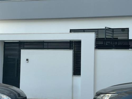 eine weiße Garage mit einem weißen Tor und schwarzen Fensterläden in der Unterkunft New S1 ground floor independent in Tunis