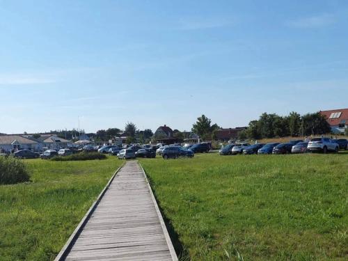 a wooden walkway in a field with cars parked at 6 person holiday home in Hadsund-By Traum in Hadsund