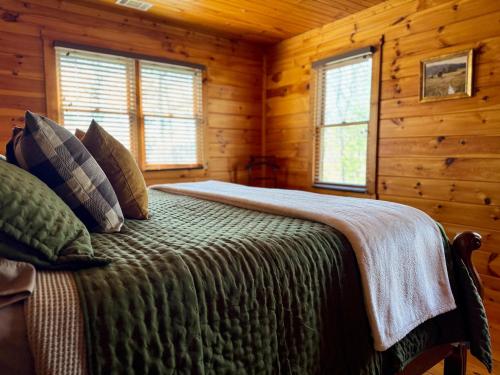 a bedroom with a bed in a log cabin at The Tree House- Wifi- Firepit- 2 Fireplaces-Garden Tub-Free Activities in Morganton
