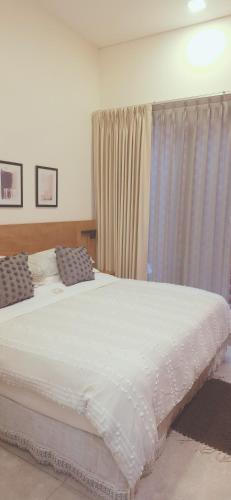 a bedroom with a large white bed and a window at CASA DON JULIAN in Oaxaca City