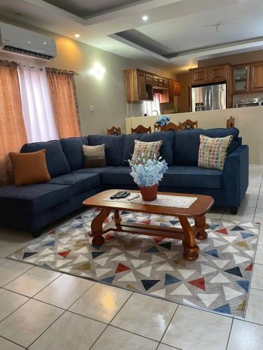 a living room with a blue couch and a coffee table at Comfortable home in San Fernando in San Fernando