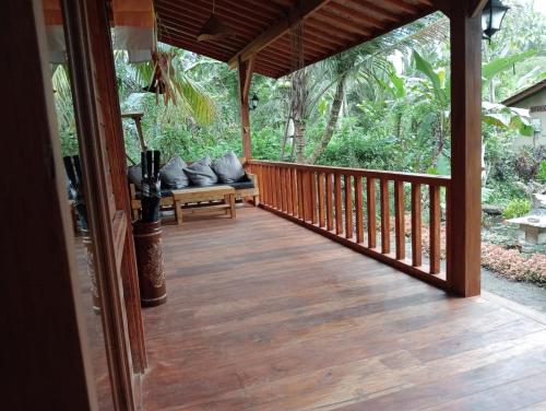 a wooden porch with a bench on a deck at Loka Amertha in Sidemen
