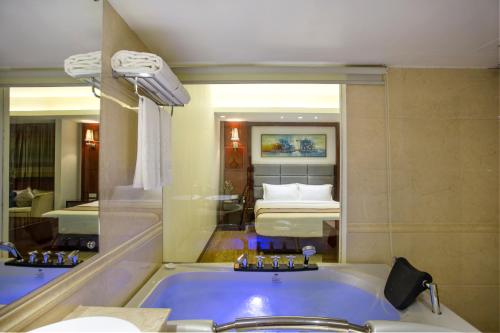 a bathroom with a tub and a bedroom with a bed at Bengal Blueberry in Dhaka