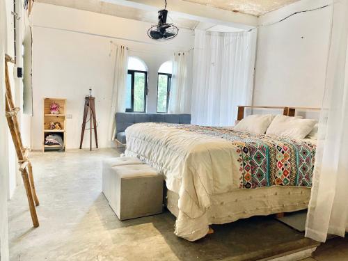 a bedroom with a large bed and a table at Casa Coati in Isla Mujeres