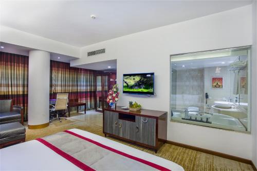 a hotel room with a bed and a tub and a sink at Bengal Blueberry in Dhaka